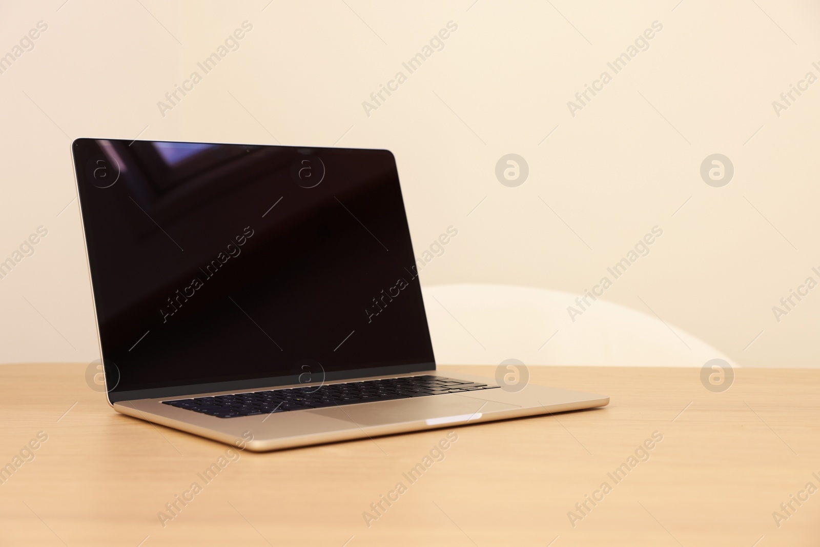 Photo of Modern laptop on wooden table. Space for text