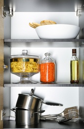 Photo of Products and kitchen utensils on modern shelving unit