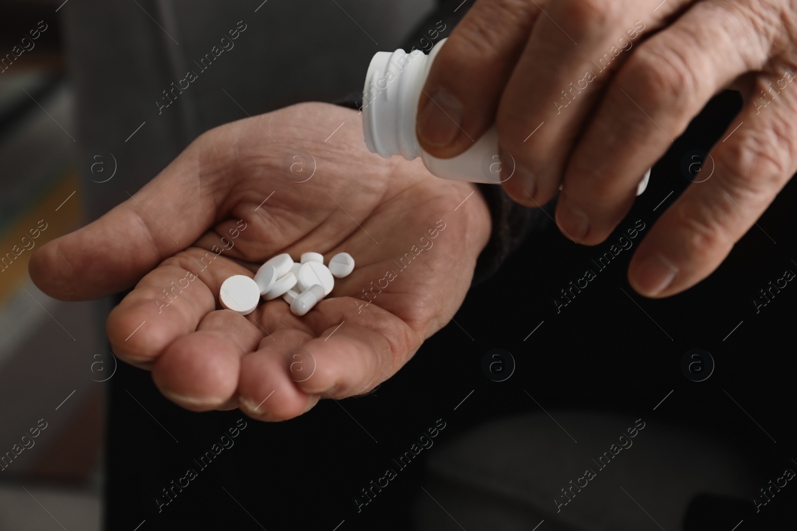 Photo of Senior man pouring pills from bottle into hand, closeup