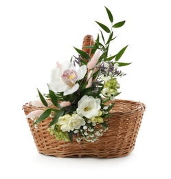 Photo of Wicker basket decorated with beautiful flowers on white background. Easter item