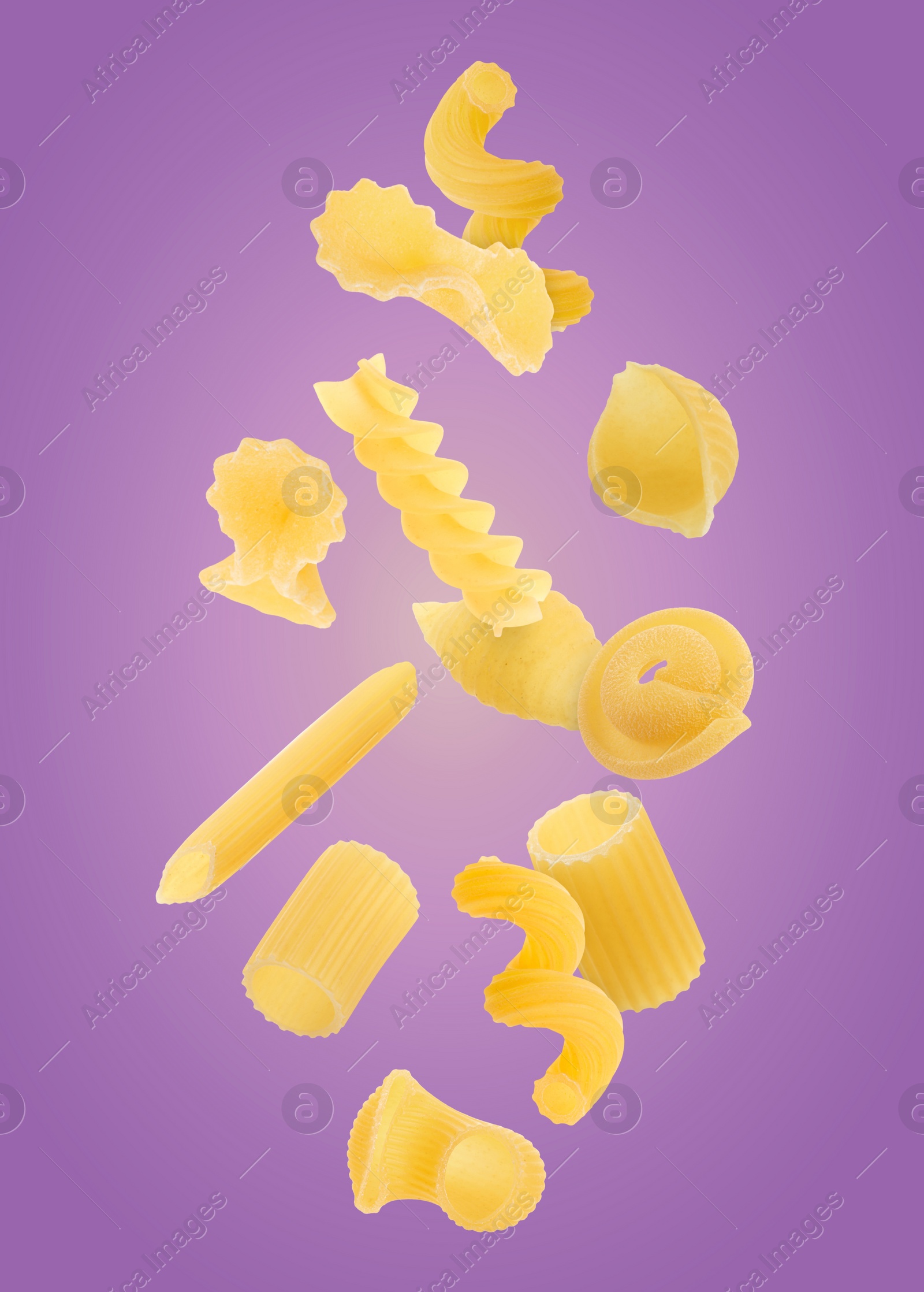 Image of Different types of pasta flying on purple background