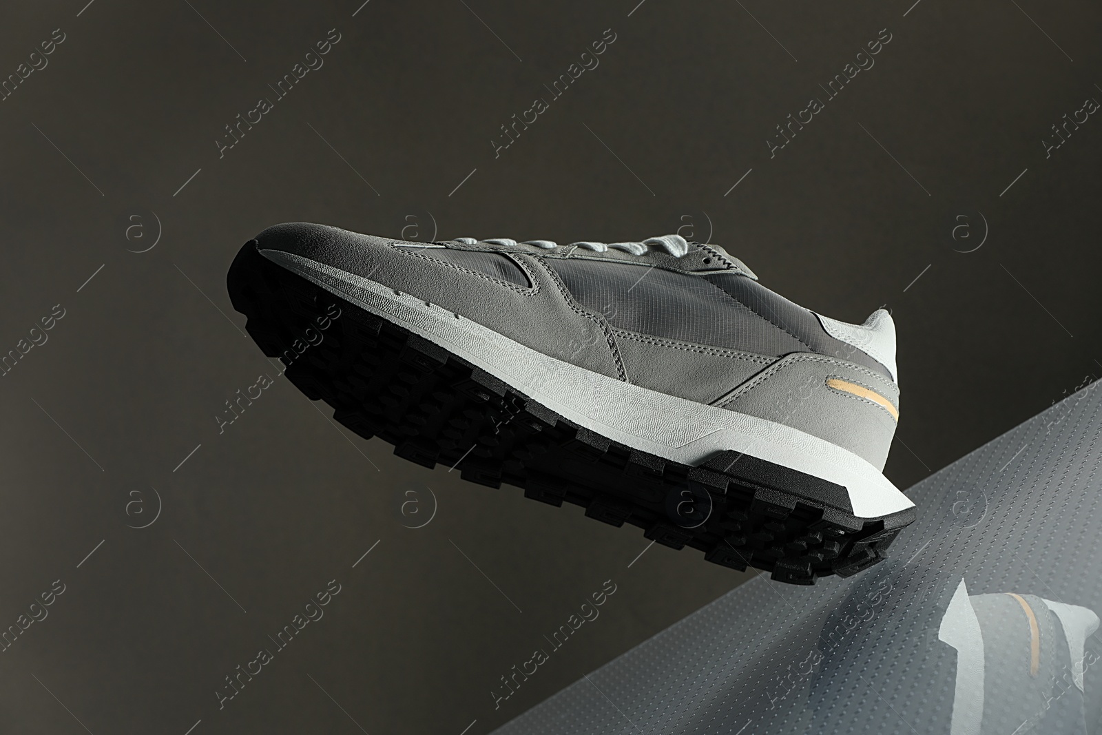 Photo of Stylish presentation of trendy sneaker against grey background