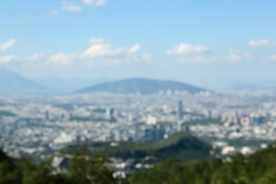 Photo of Blurred view of city with mountains under beautiful sky