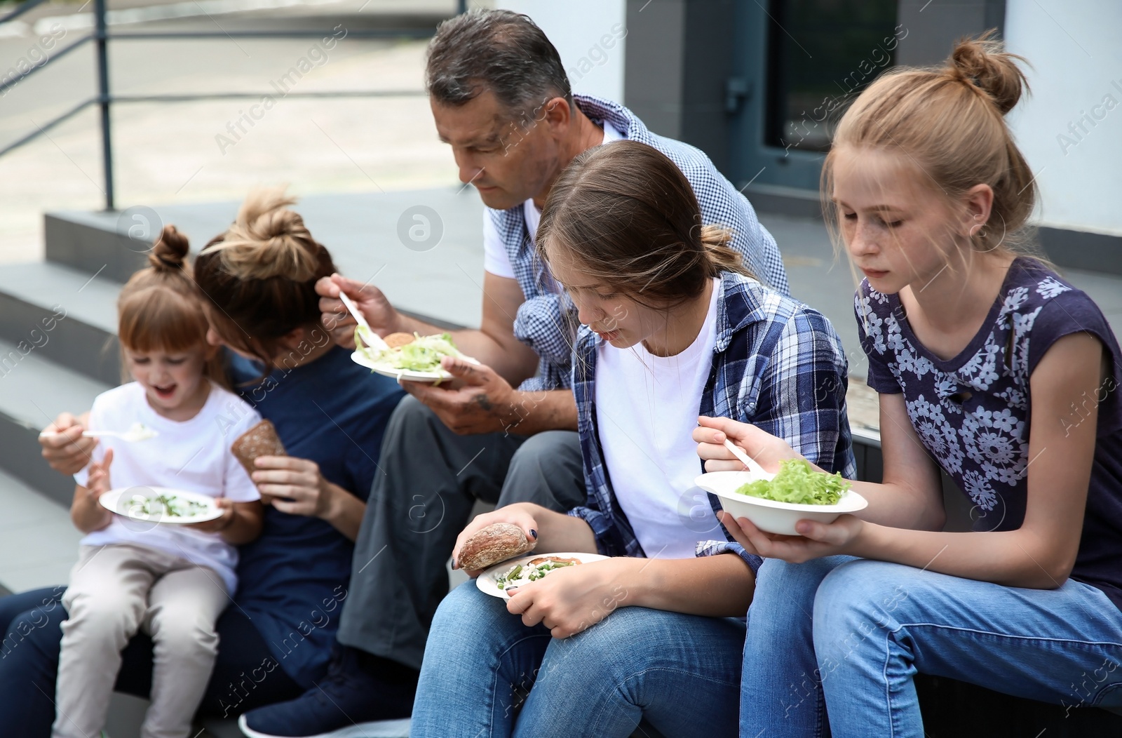 Photo of Poor people eating donated food on street