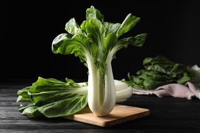 Photo of Fresh green pak choy cabbages on black wooden table