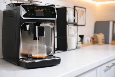 Photo of Modern coffee machine making espresso in kitchen, space for text