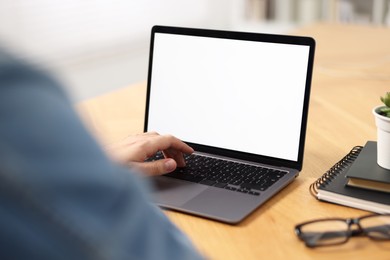 Photo of Young man watching webinar at table indoors, closeup