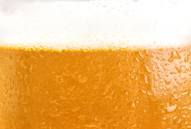 Photo of Glass of tasty beer with foam, closeup