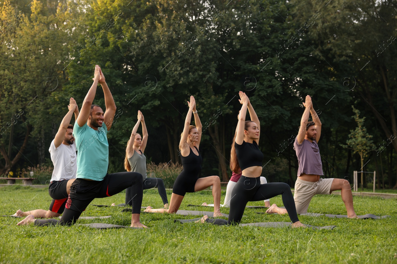 Photo of Group of people practicing yoga on mats outdoors