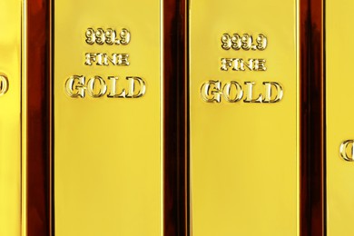 Photo of Many shiny gold bars as background, top view