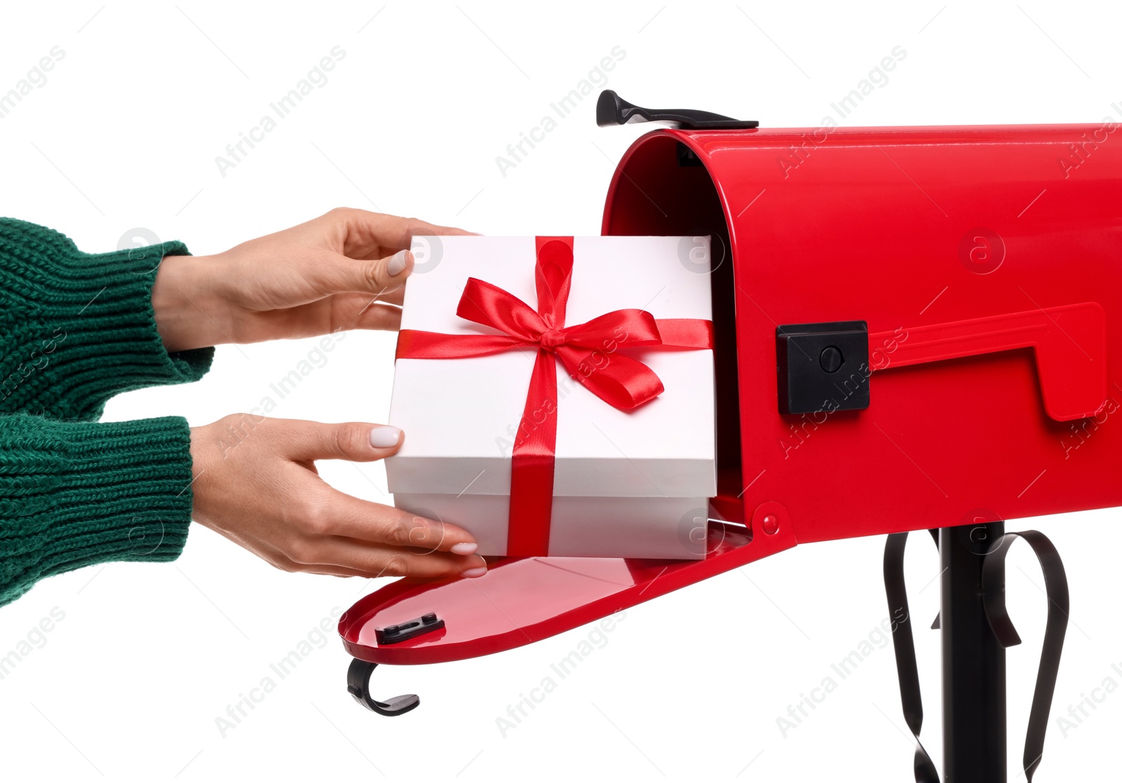 Photo of Woman putting Christmas gift into mailbox on white background, closeup. Sending present by mail