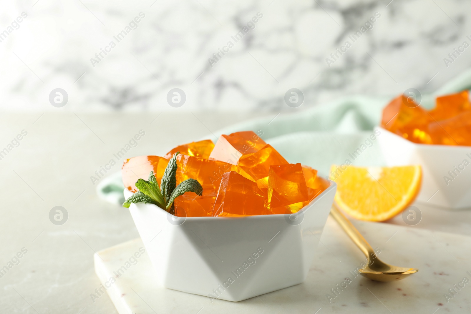 Photo of Orange jelly in bowl on table, closeup