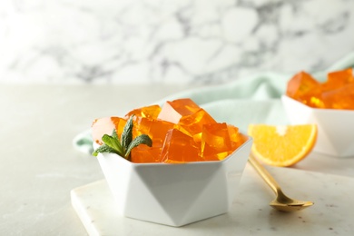 Photo of Orange jelly in bowl on table, closeup