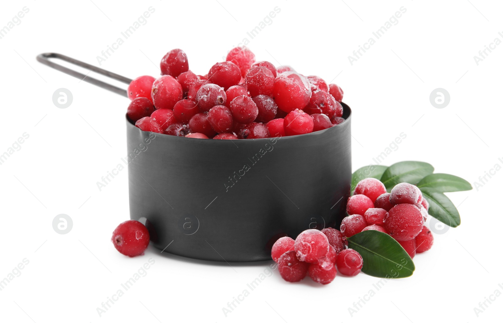 Photo of Frozen red cranberries in scoop and green leaves isolated on white