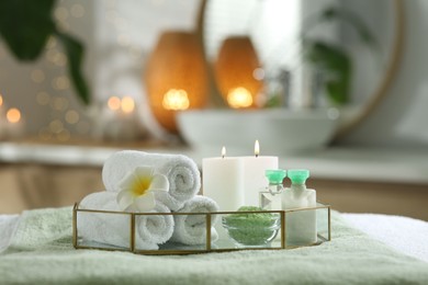 Composition with different spa products and burning candles on table indoors