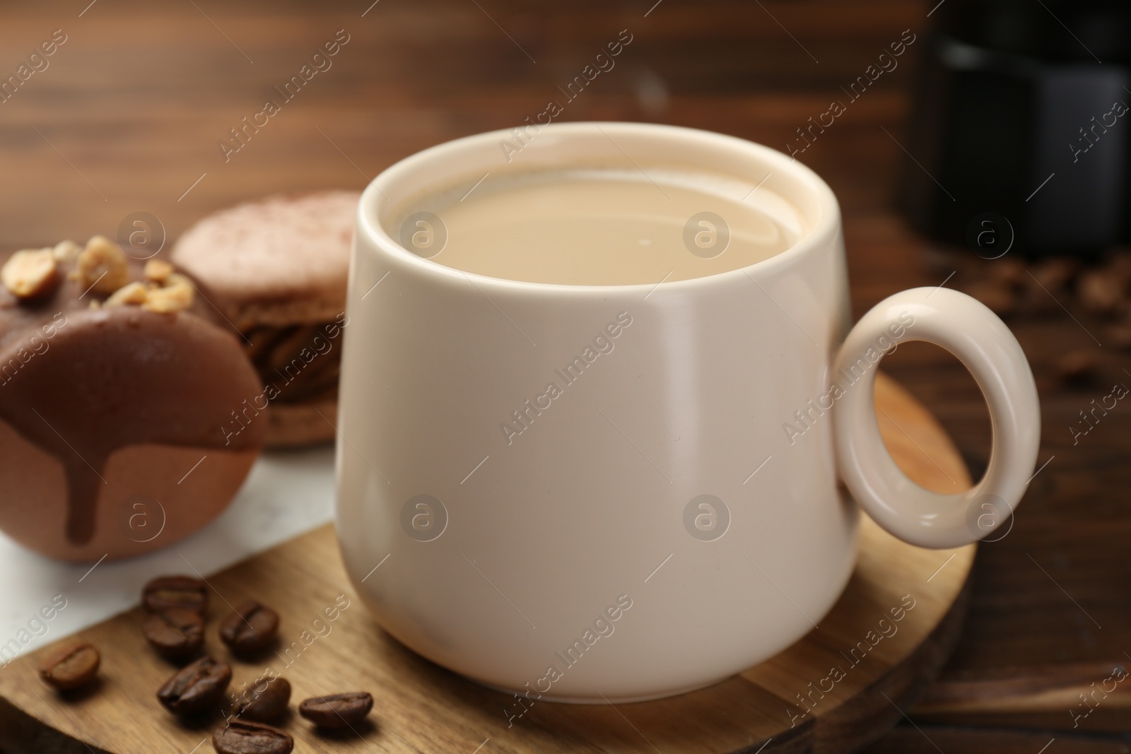 Photo of Cup of coffee and delicious macarons on wooden table, closeup