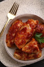Photo of Delicious stuffed cabbage rolls cooked with homemade tomato sauce on table, top view