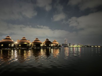 Beautiful view of night cityscape with sea and illuminated buildings