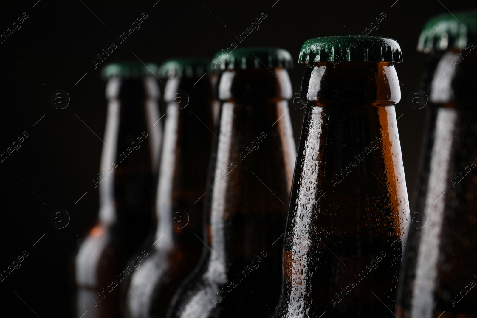 Photo of Many bottles of beer on dark background, closeup