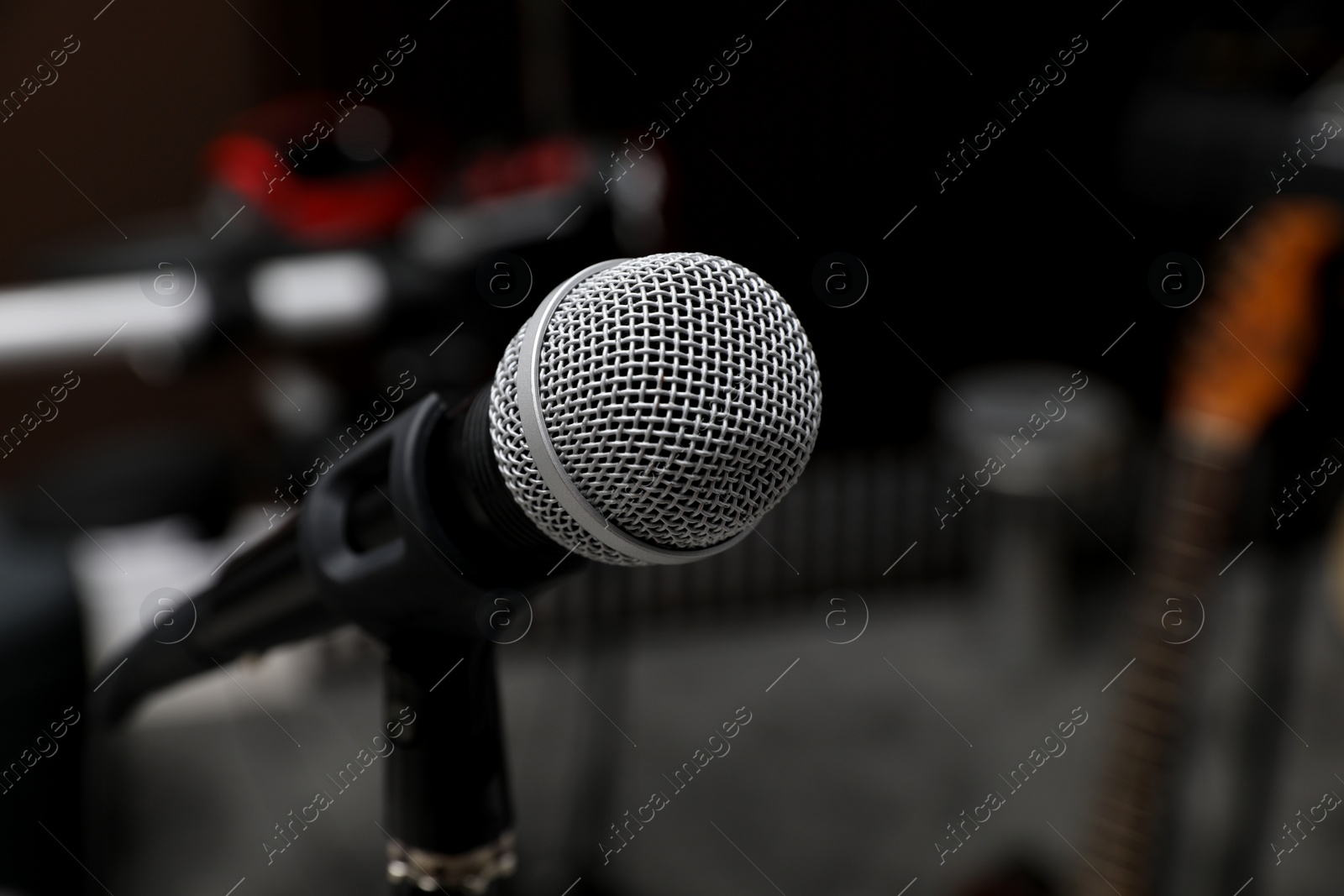 Photo of Modern microphone at recording studio, closeup with space for text. Music band practice