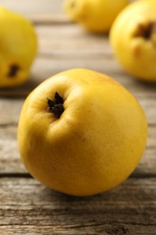 Tasty ripe quinces on wooden table, closeup