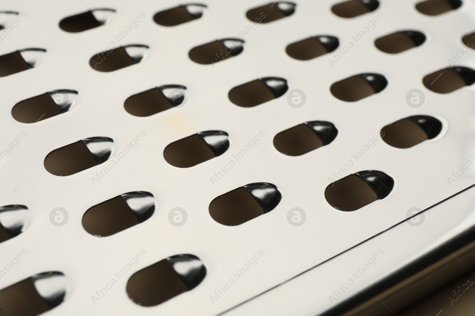 Photo of Modern metal grater as background, closeup view