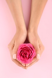 Photo of Closeup view of woman with rose on color background. Spa treatment