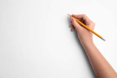 Photo of Woman holding pencil on white background, top view