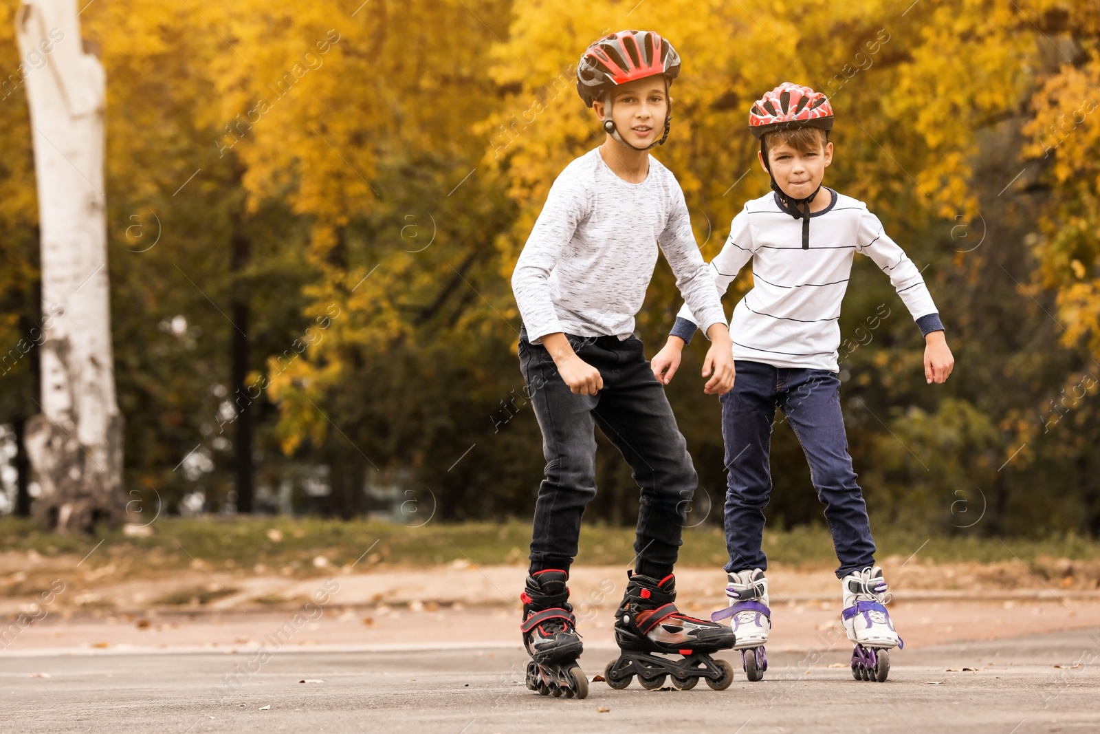 Photo of Happy children roller skating in autumn park