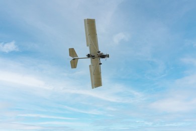 Photo of White ultralight aircraft flying in sky, bottom view