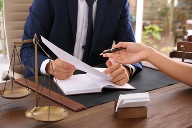 Photo of Lawyer working with client at table in office, focus on hands