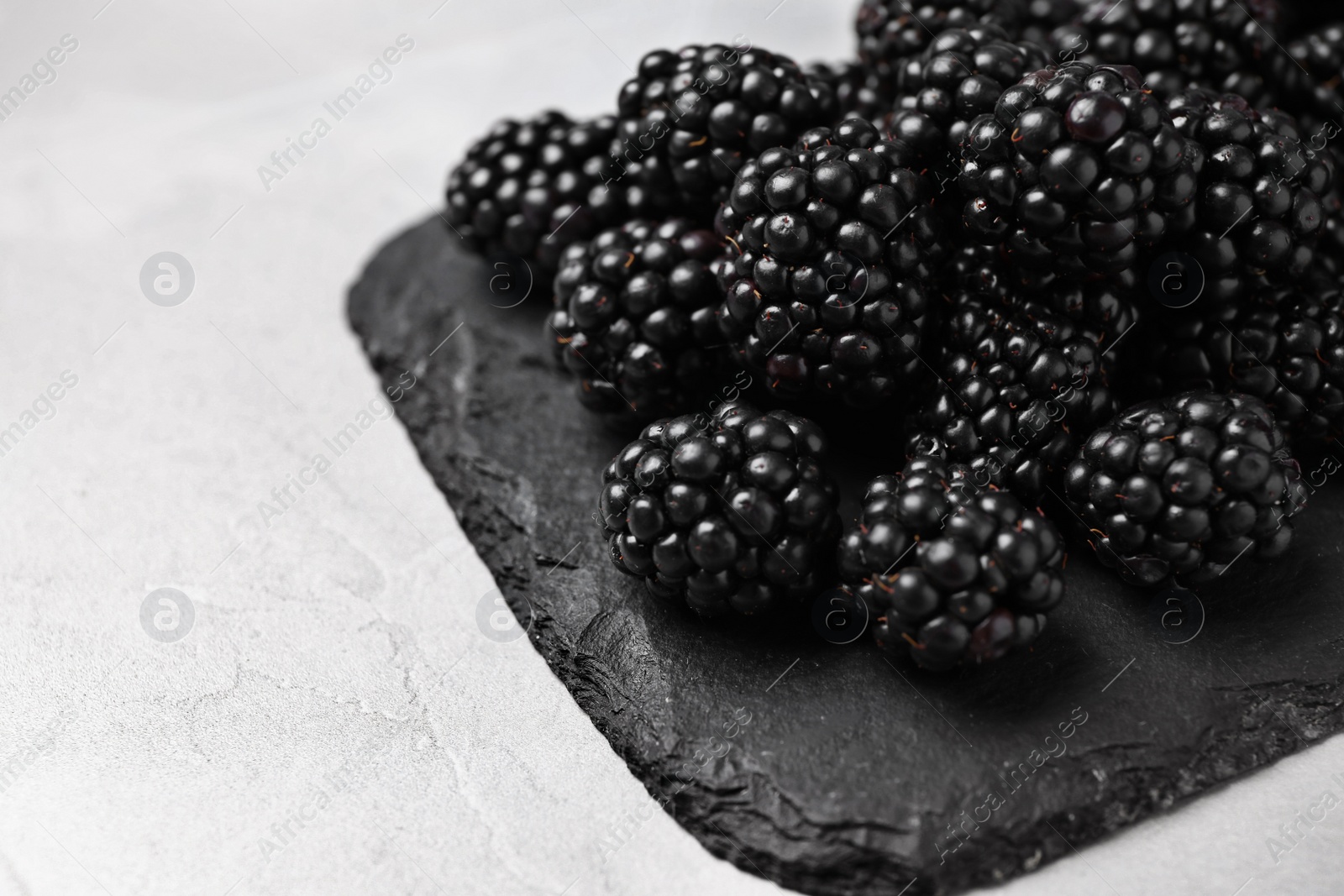 Photo of Fresh ripe blackberries on white table, closeup