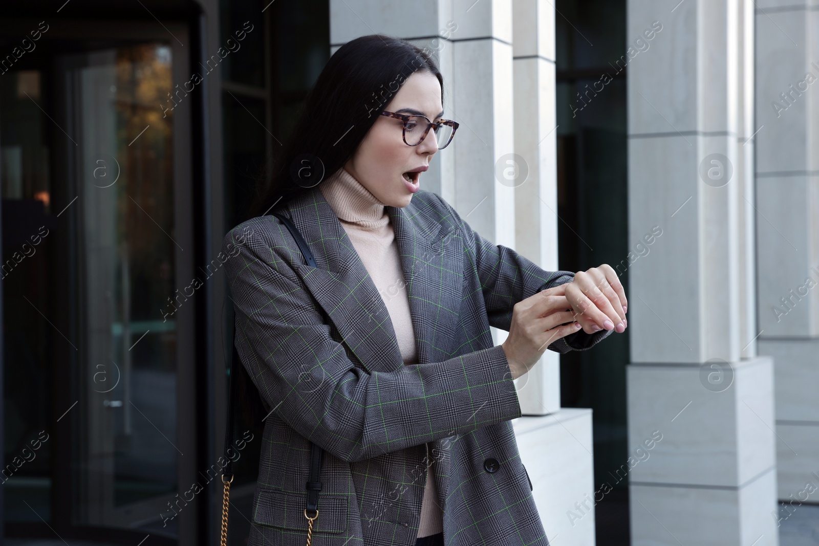 Photo of Emotional woman checking time on watch outdoors. Being late concept