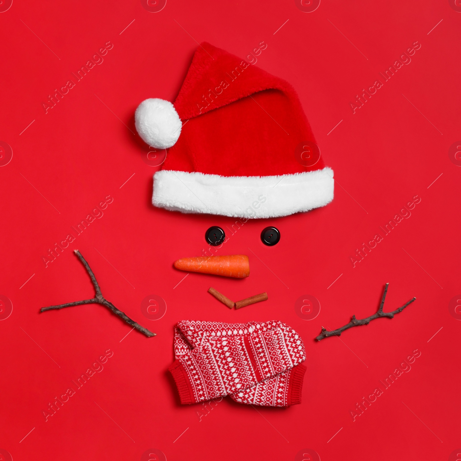 Photo of Funny snowman made with different elements on red background, flat lay