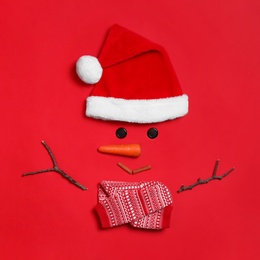 Funny snowman made with different elements on red background, flat lay