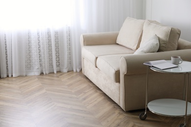 Photo of Parquet floor in room with sofa and coffee table