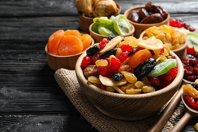 Composition with different dried fruits on wooden background, space for text. Healthy lifestyle