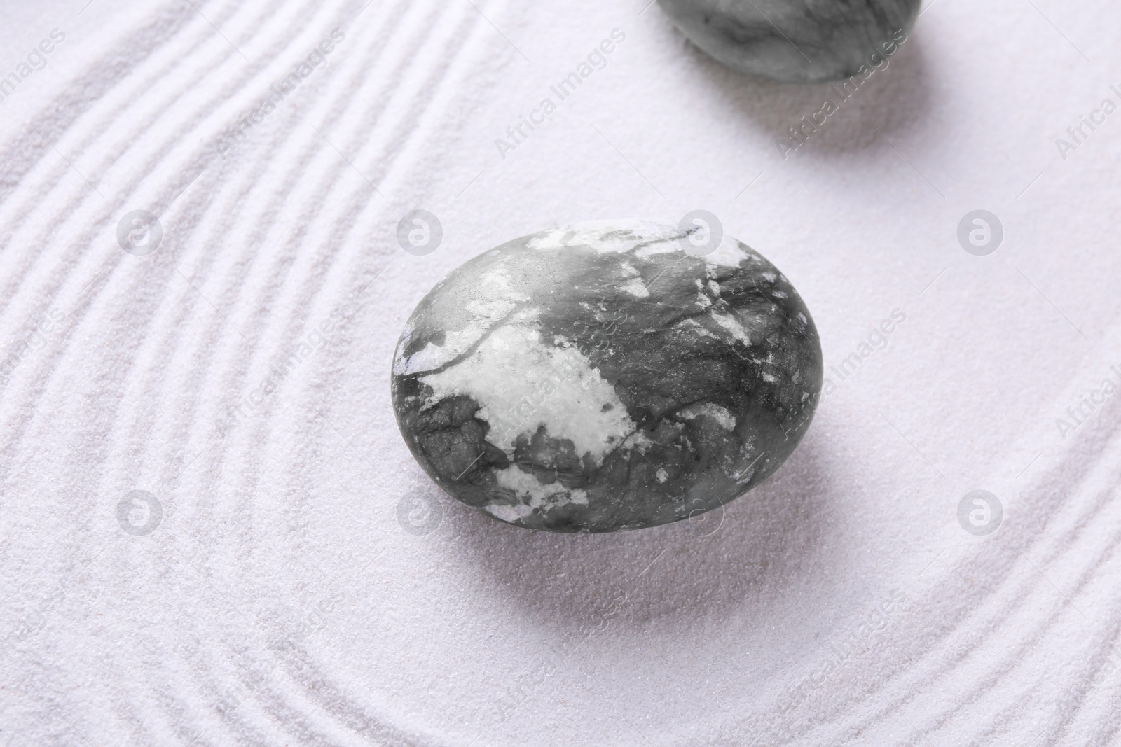 Photo of Stones on sand with pattern, top view. Zen concept