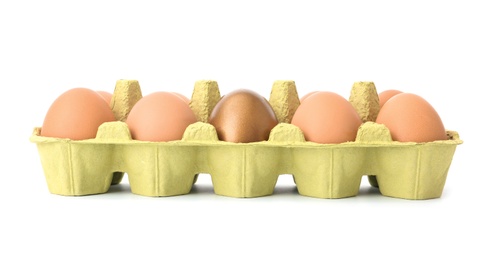 Eggs with golden one in carton on white background