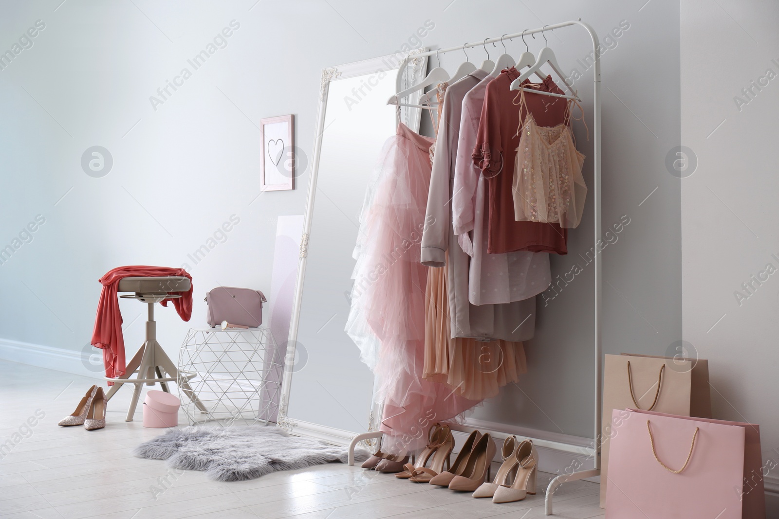 Photo of Modern dressing room interior with clothing rack and mirror