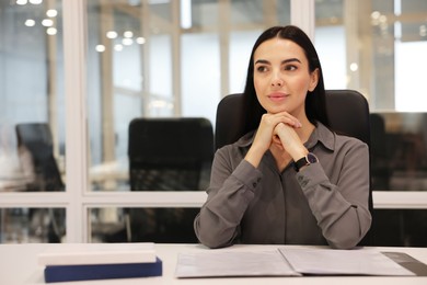Photo of Confident woman at table in office, space for text. Lawyer, businesswoman, accountant or manager