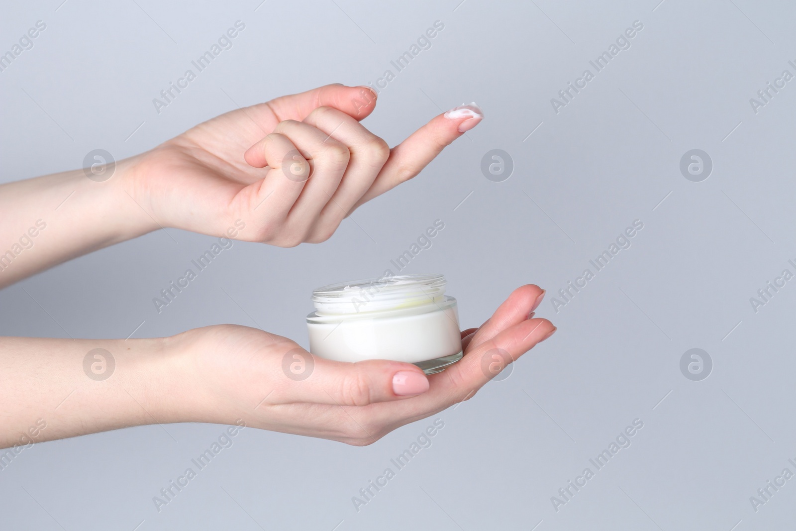 Photo of Woman with jar of cream on grey background, closeup. Space for text