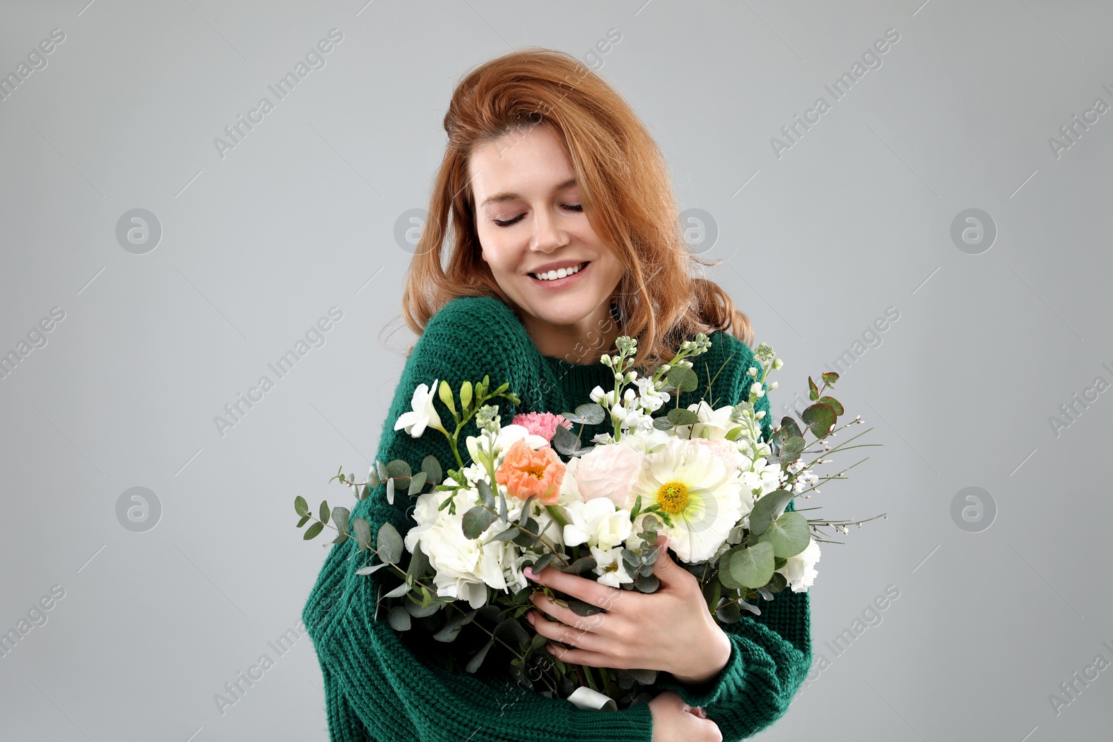 Photo of Beautiful woman with bouquet of flowers on grey background