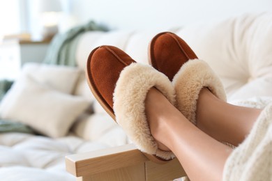 Woman wearing soft comfortable slippers at home, closeup