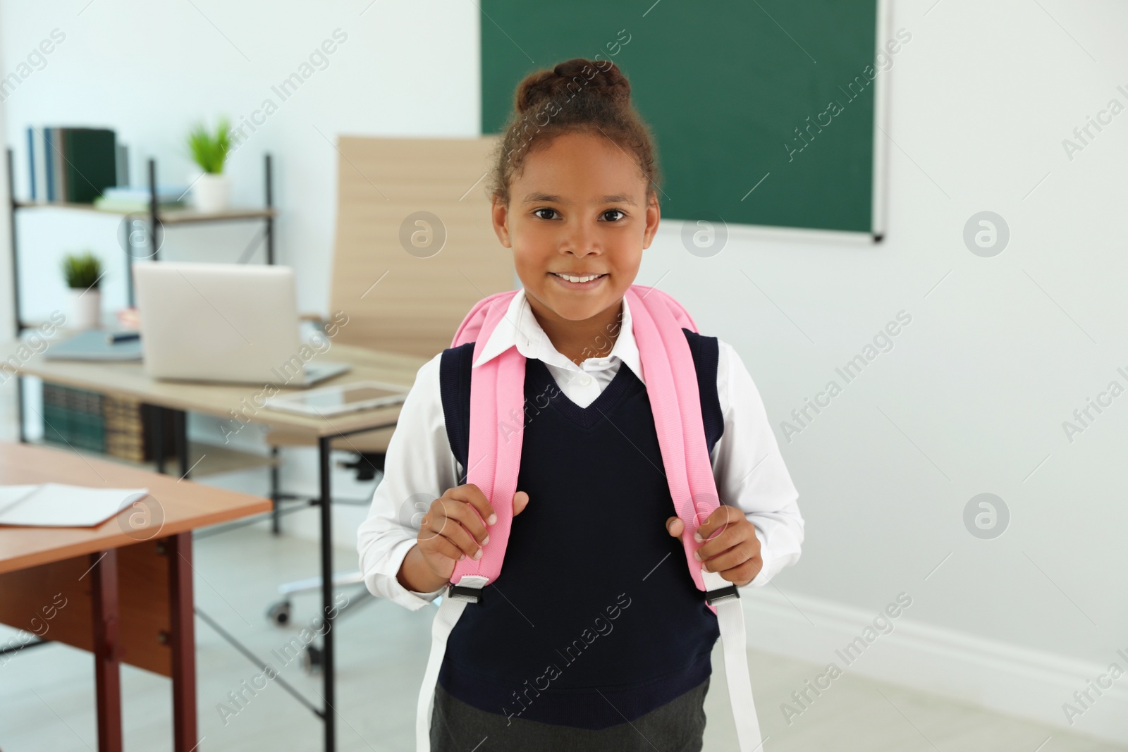 Photo of African-American girl wearing school uniform in classroom