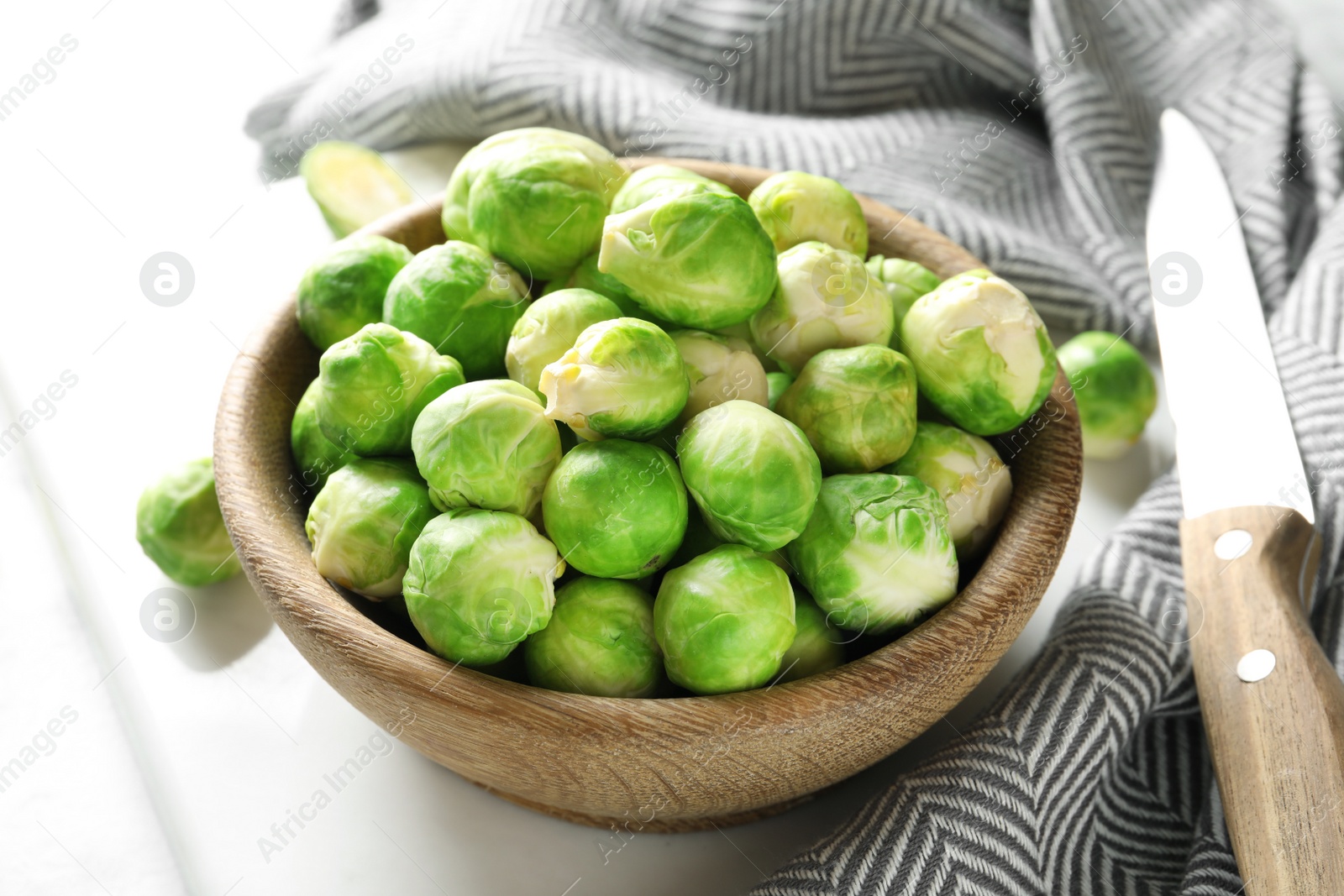 Photo of Bowl with fresh Brussels sprouts on table