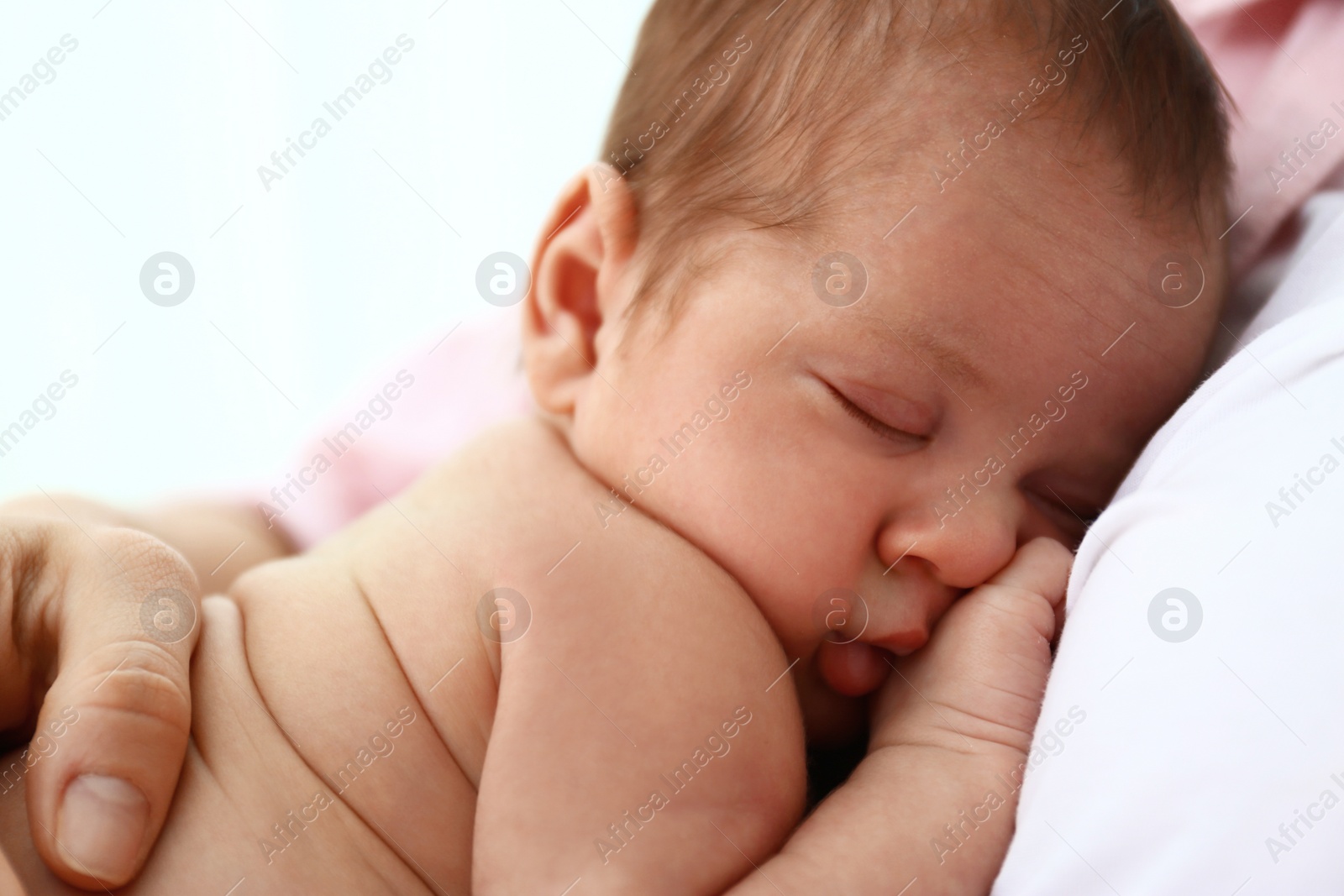 Photo of Young mother with her little baby on light background, closeup