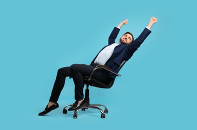 Photo of Young businessman stretching in comfortable office chair on turquoise background