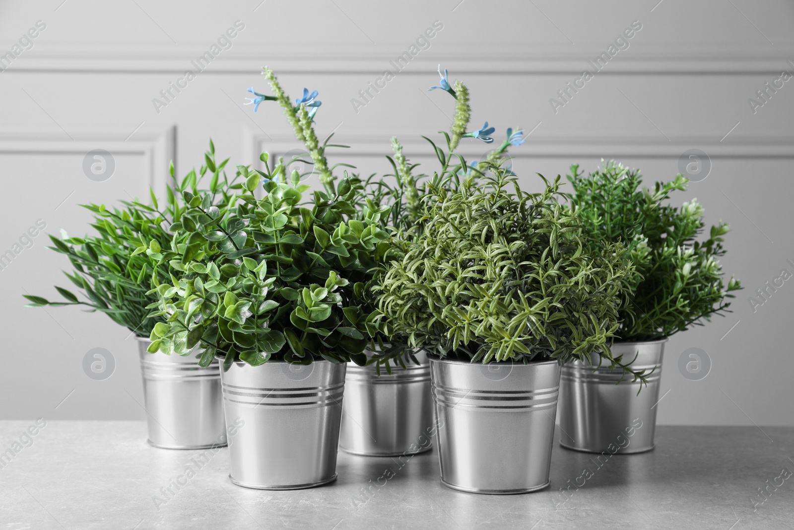 Photo of Different artificial potted herbs on light grey table