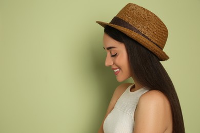 Photo of Beautiful young woman wearing straw hat on olive  background, space for text. Stylish headdress